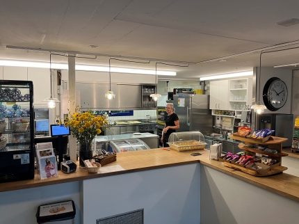 Kaffitheke mit verschiedenen Kleinigkeiten zu Essen, im Hintergrund die Küche