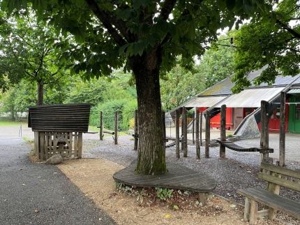 Kleinkinderkletterparcours mit Häuschen und Baum mit Sitzbank