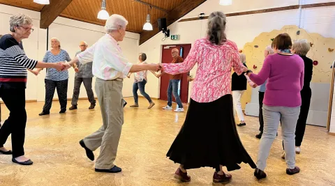 Seniorinnen und Senioren tanzen einen Kreistanz