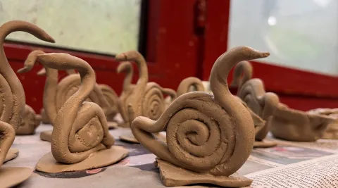 Eine Gruppe Schwäne aus frischem Ton auf einer Zeitung